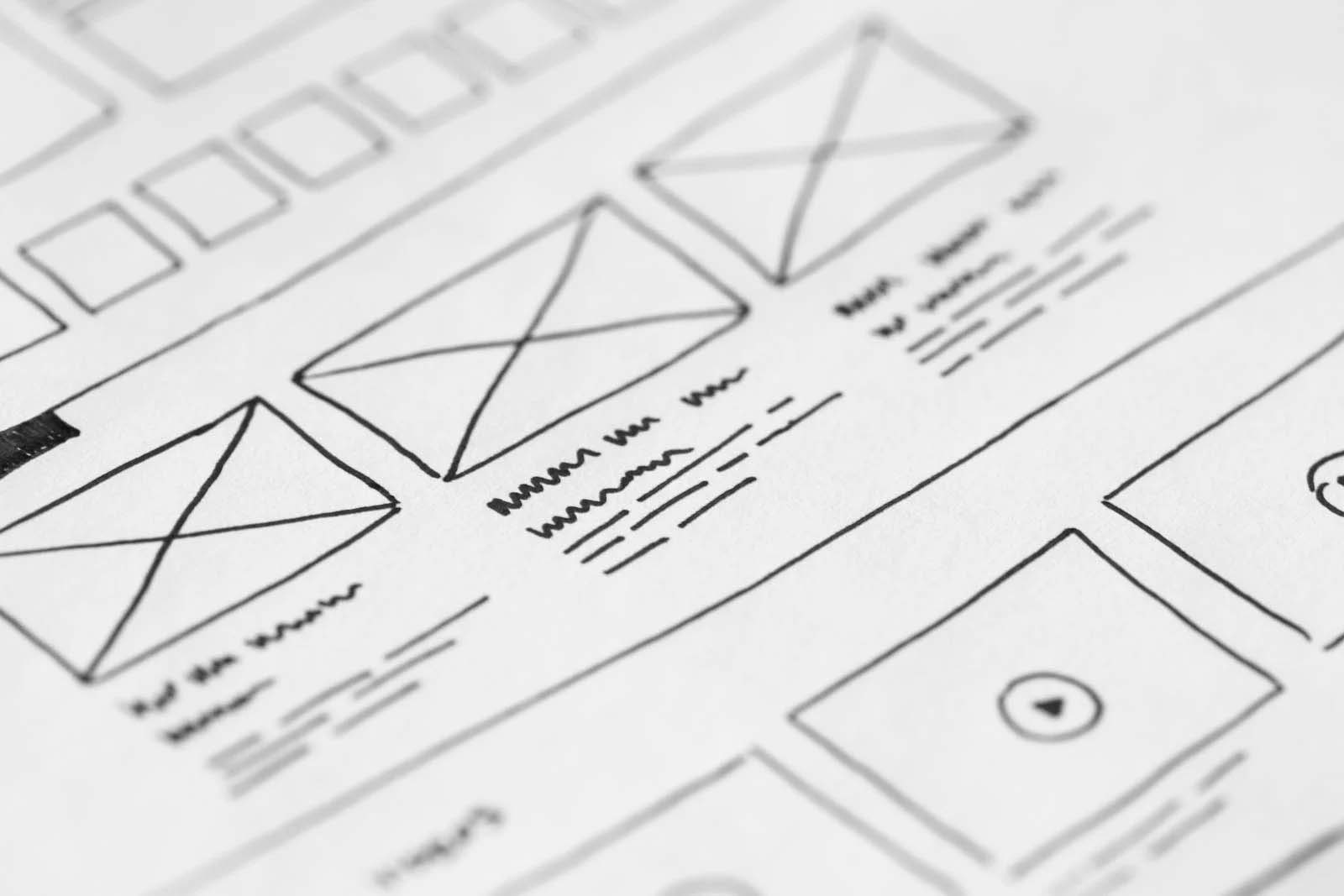 Wireframe mockup of a website on pen and paper.