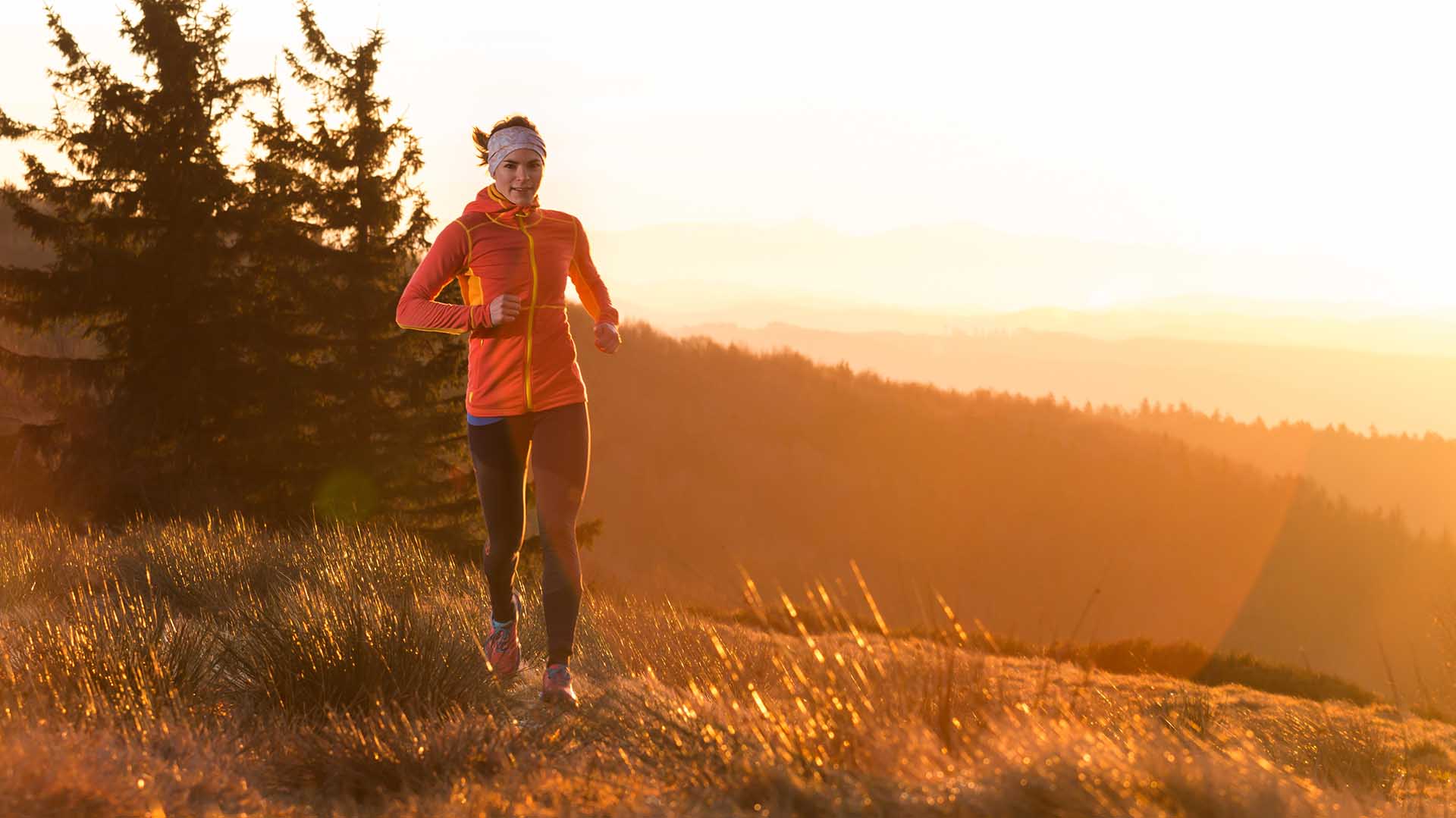 A woman jogging in the morning sun.